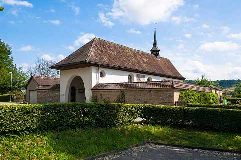 Ansicht der Kapelle mit Eingang und Einfriedung vom nahen Parkplatz aus